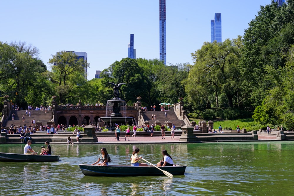 close-up photography of people riding boat near water fountain