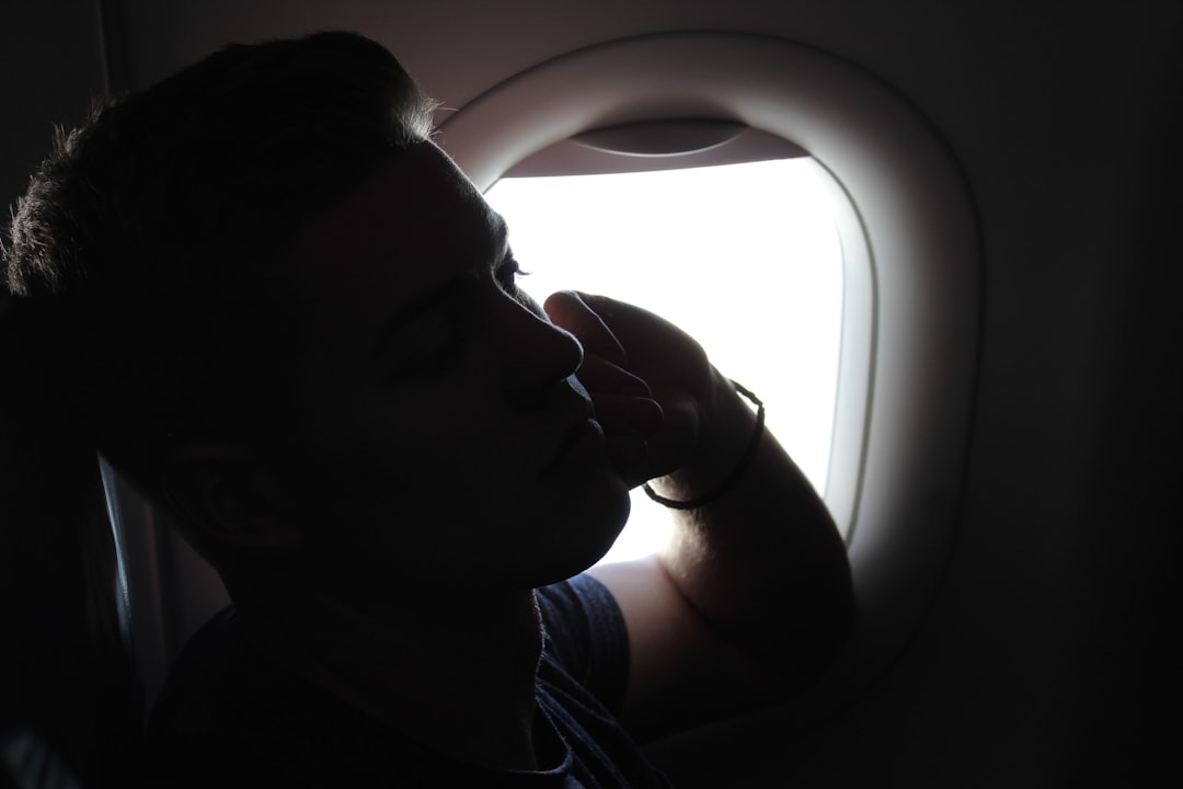 man sitting beside airliner window
