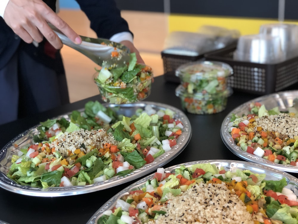 a table topped with plates of food and serving utensils