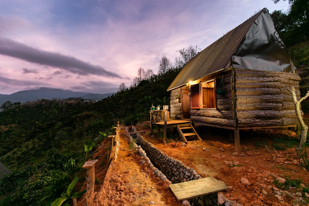 Graue Holzhütte mit Veranda in der Morgendämmerung