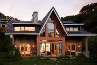 A sleek modern smart home illuminated by soft ambient lighting showcasing solar panels on the roof during sunset.