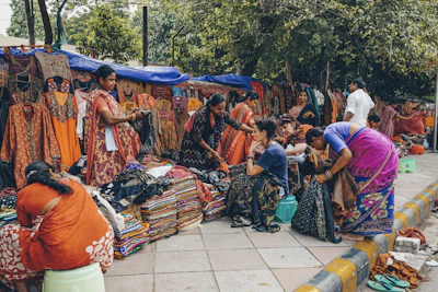 A vibrant street scene in India with colorful saris and bustling markets under bright sunlight.
