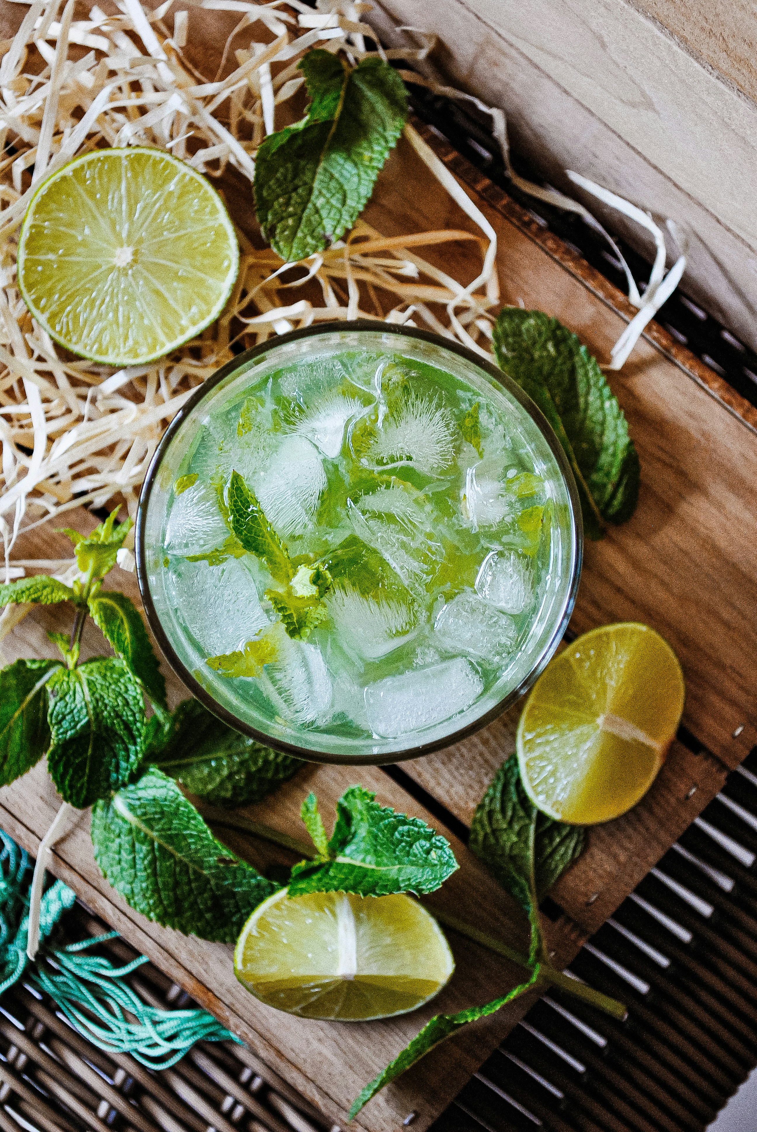 a glass of mojito with limes and mints