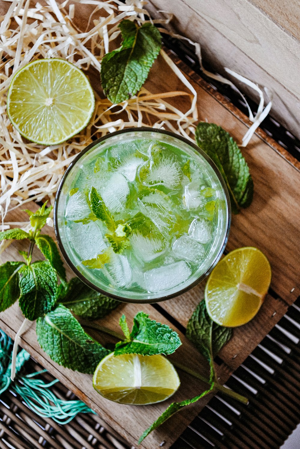 a glass of mojito with limes and mints