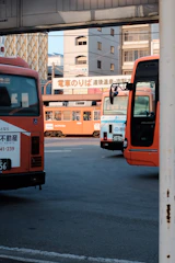 A busy northern bus station with various branded buses lined up.