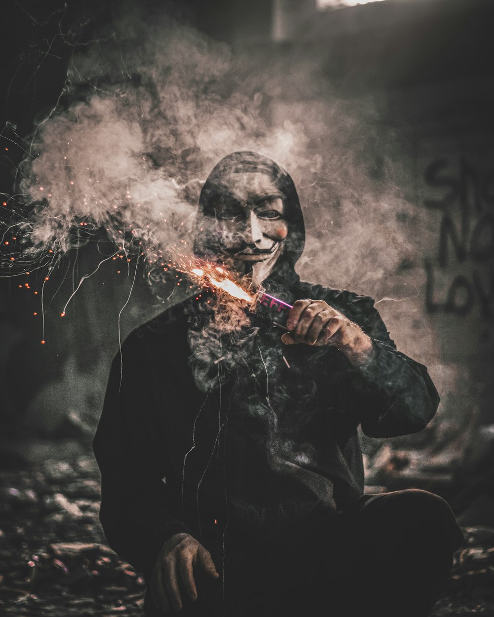 man holding sparkler wearing guy fawkes mask