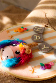 Close-up of a delicate crocheted unicorn mane with vibrant, swirling yarn colors.