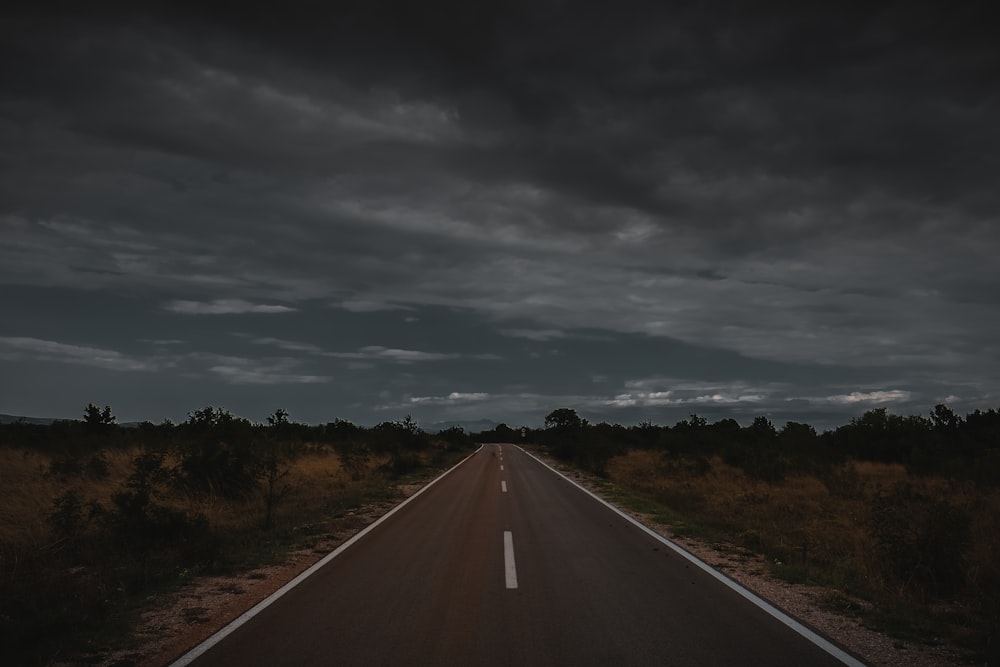 gray road under cloudy sky