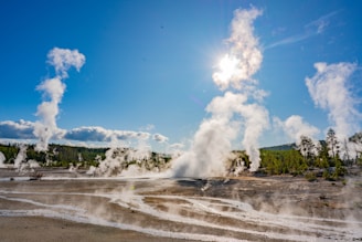 Close-up of geothermal steam vents releasing natural vapor into the sky at sunrise.