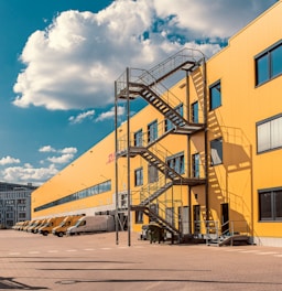 gray metal staircase on orange DHL building