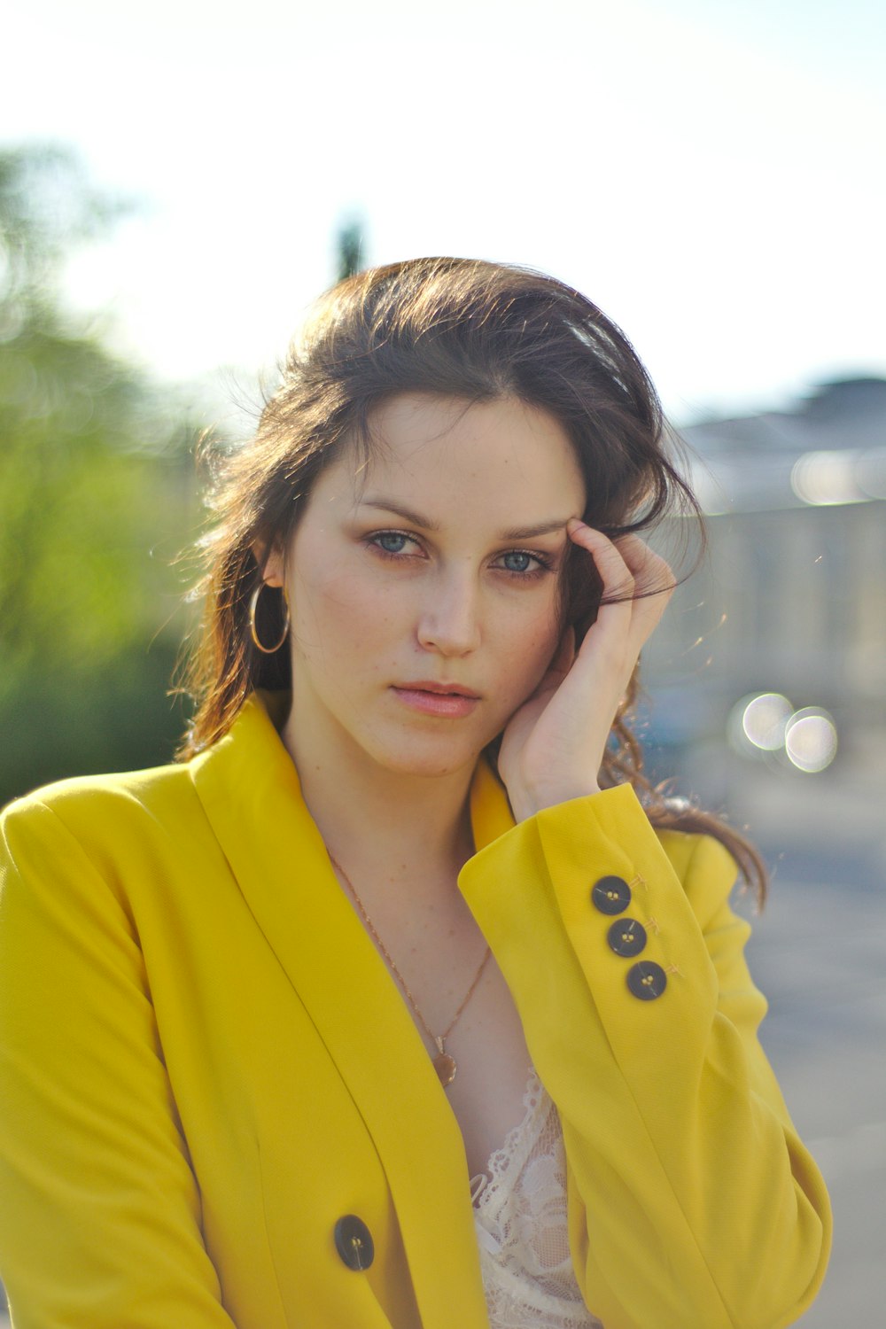 a woman in a yellow jacket is posing for a picture