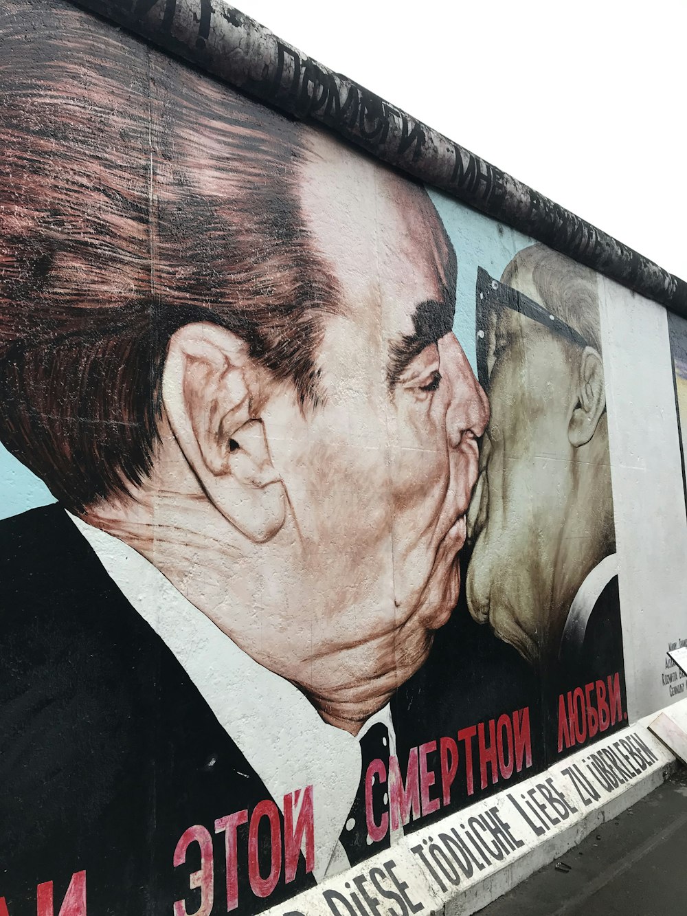 um grande mural de um homem beijando outro homem