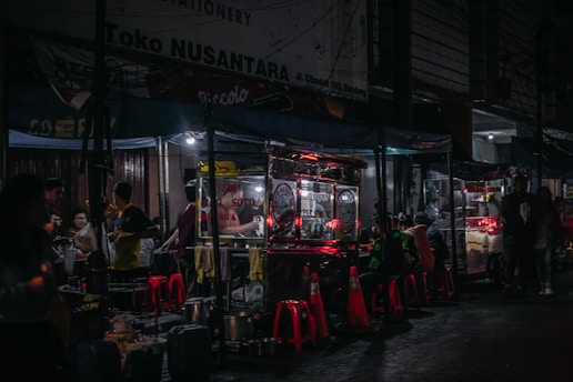 a group of people standing around a booth at night