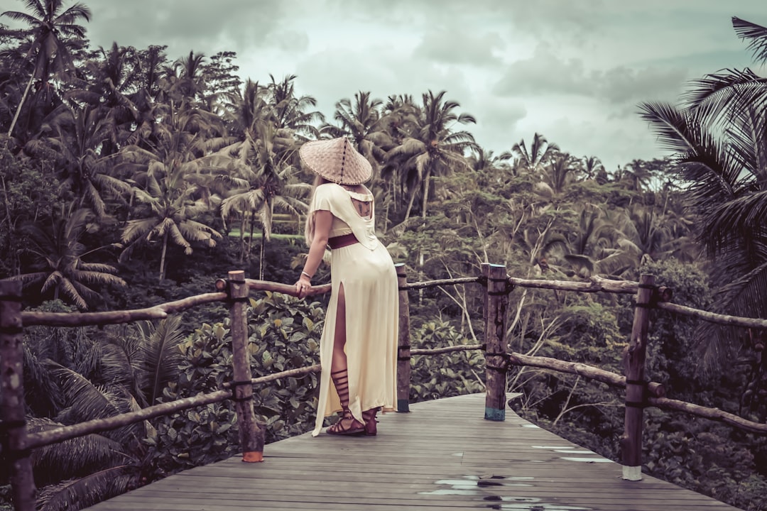 woman wears conical hat on wooden pathway