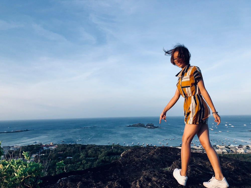 woman on top of green mountain