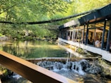 Dining area with tables set near a trout pond, blending nature and comfort.