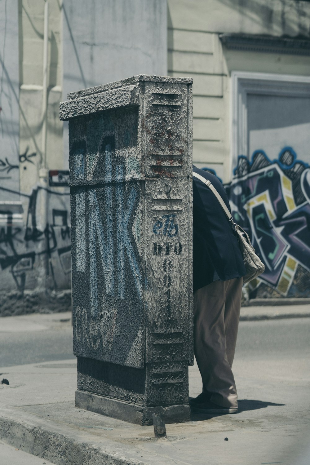 man hide behind concrete wall