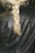 A close-up of a blonde braid resting on the back of a black leather jacket.