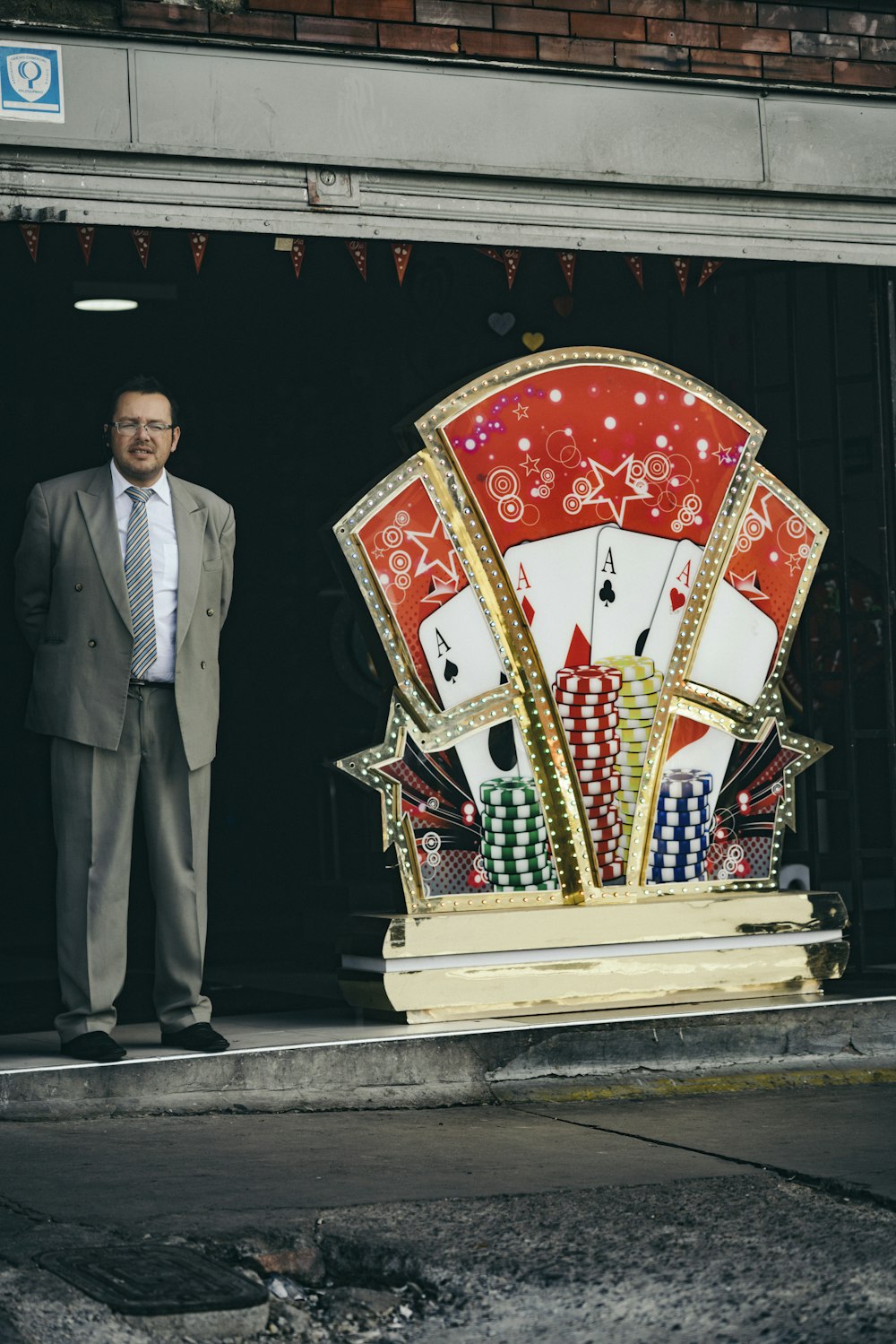 man standing beside playing cards poster