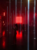 A shadowy lounge with dim lighting and abstract geometric shapes suspended above.