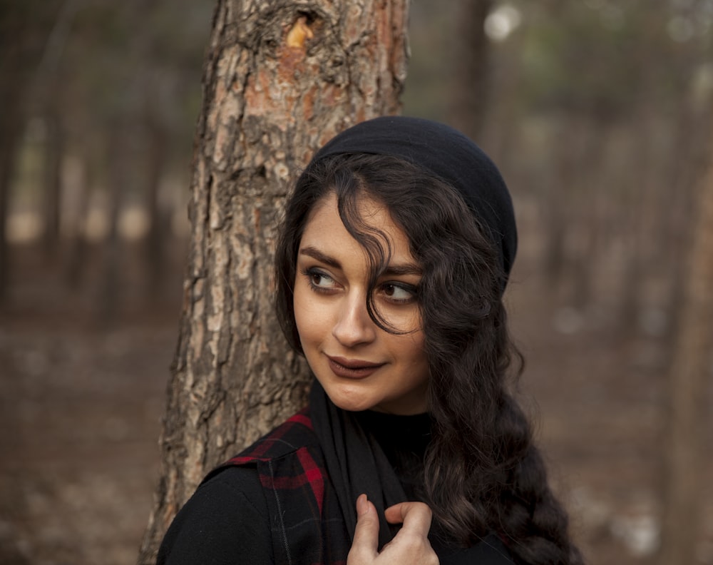 woman leaning on tree trunk