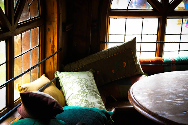 A cozy corner with colorful cushions and soft natural light filtering through a window.