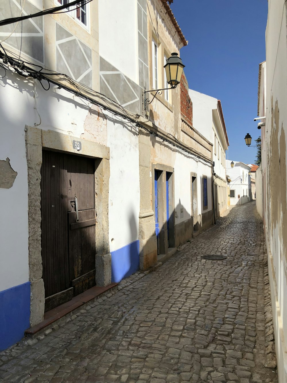 empty hallway surrounded by houses under blue sky