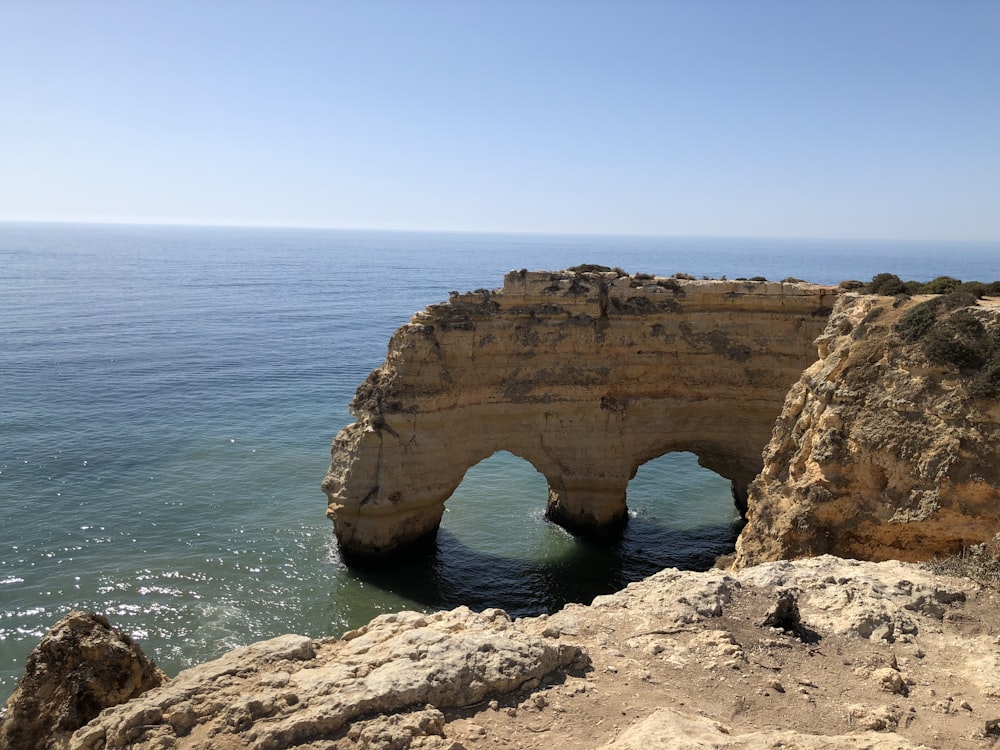 grey rock formation near body of water during daytime