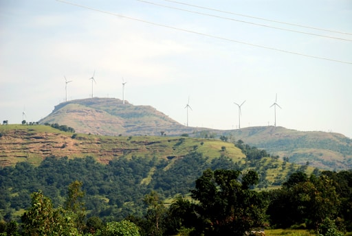 A green landscape with wind turbines symbolizing sustainable environmental practices.