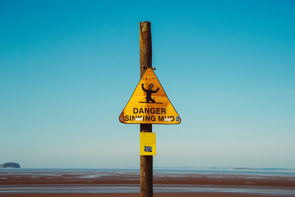 yellow Danger signage at daytime