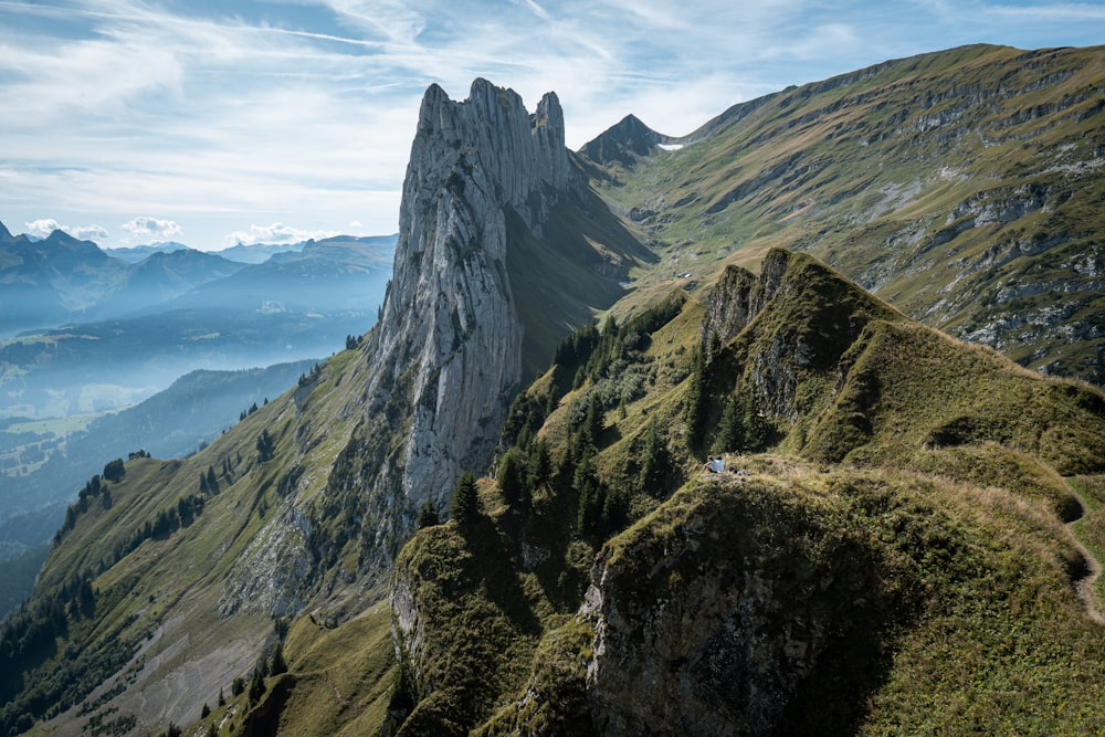 a view of a mountain range from the top of a hill