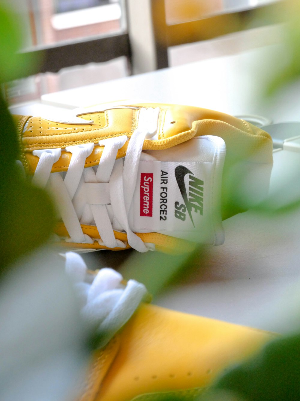 pair of white-and-yellow Nike SB Supreme low-top sneaker