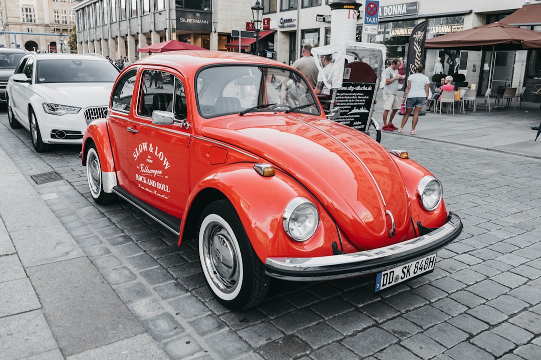 red Volkswagen Beetle on road at daytime