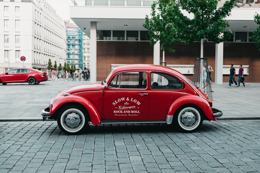 red Volkswagen Beetle near buildings