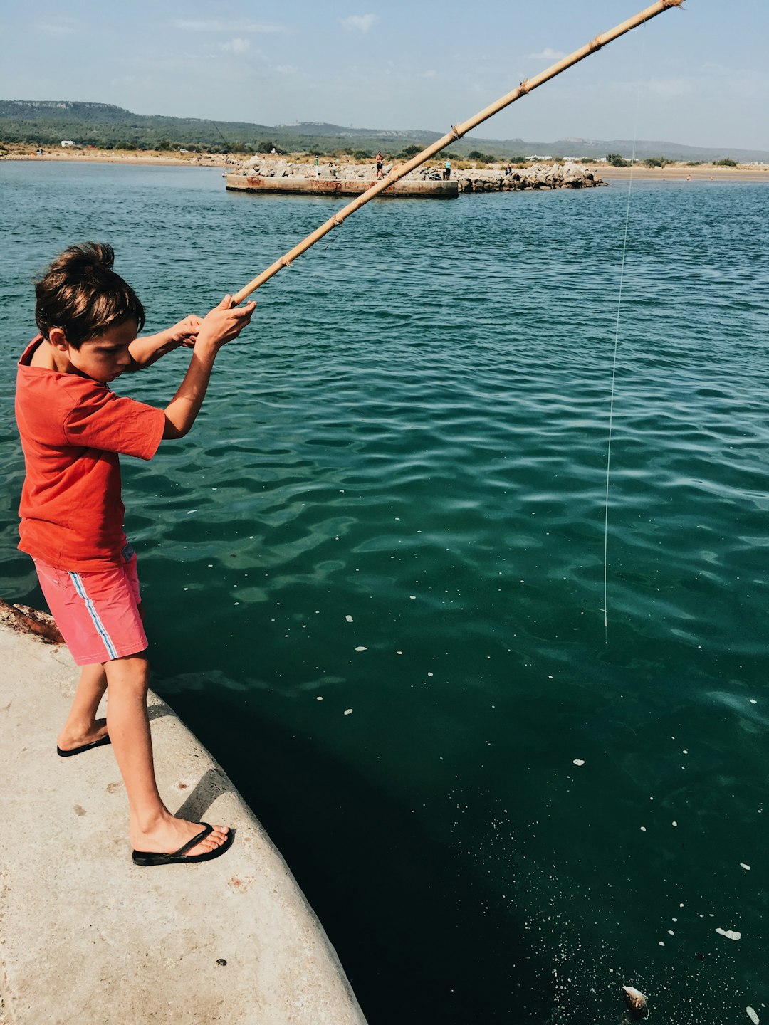 boy doing fishing during daytime