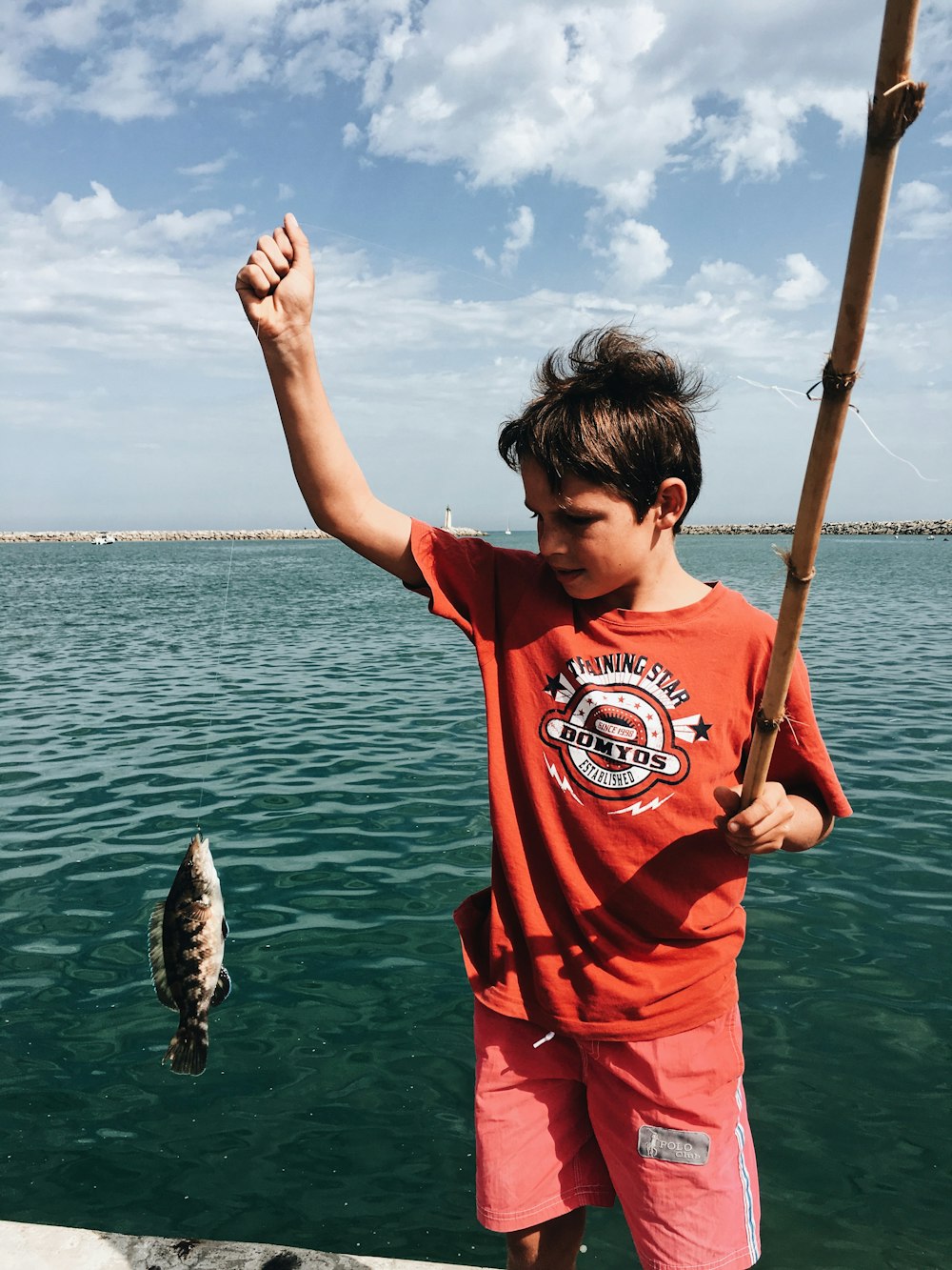 Junge hält Fisch in der Hand