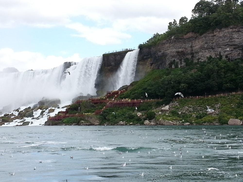 waterfalls under white and blue skies during daytime