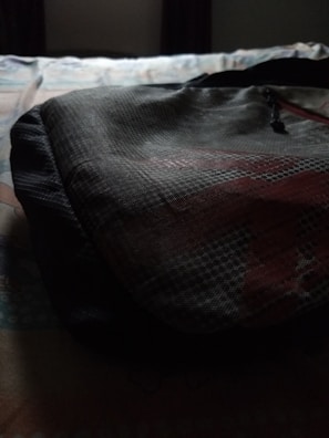 Sunlight casting shadows on a textured fabric detail from a modern backpack piece