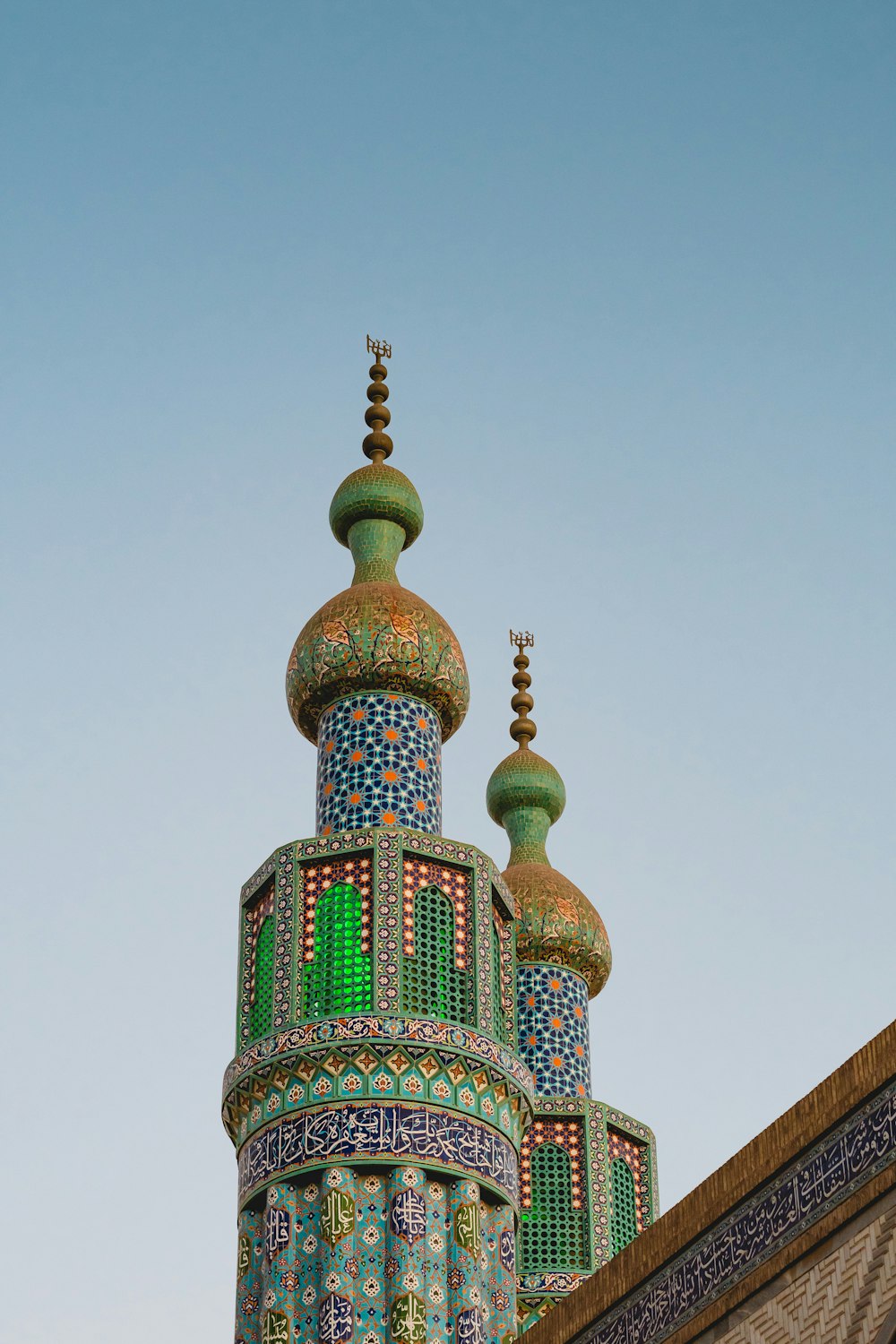 a tall building with a green and blue roof