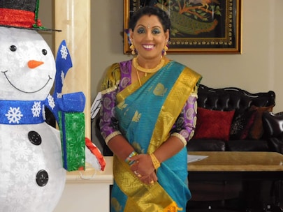 Women and children dressed in colorful winter woolens with traditional Indian patterns, set in a cozy indoor scene