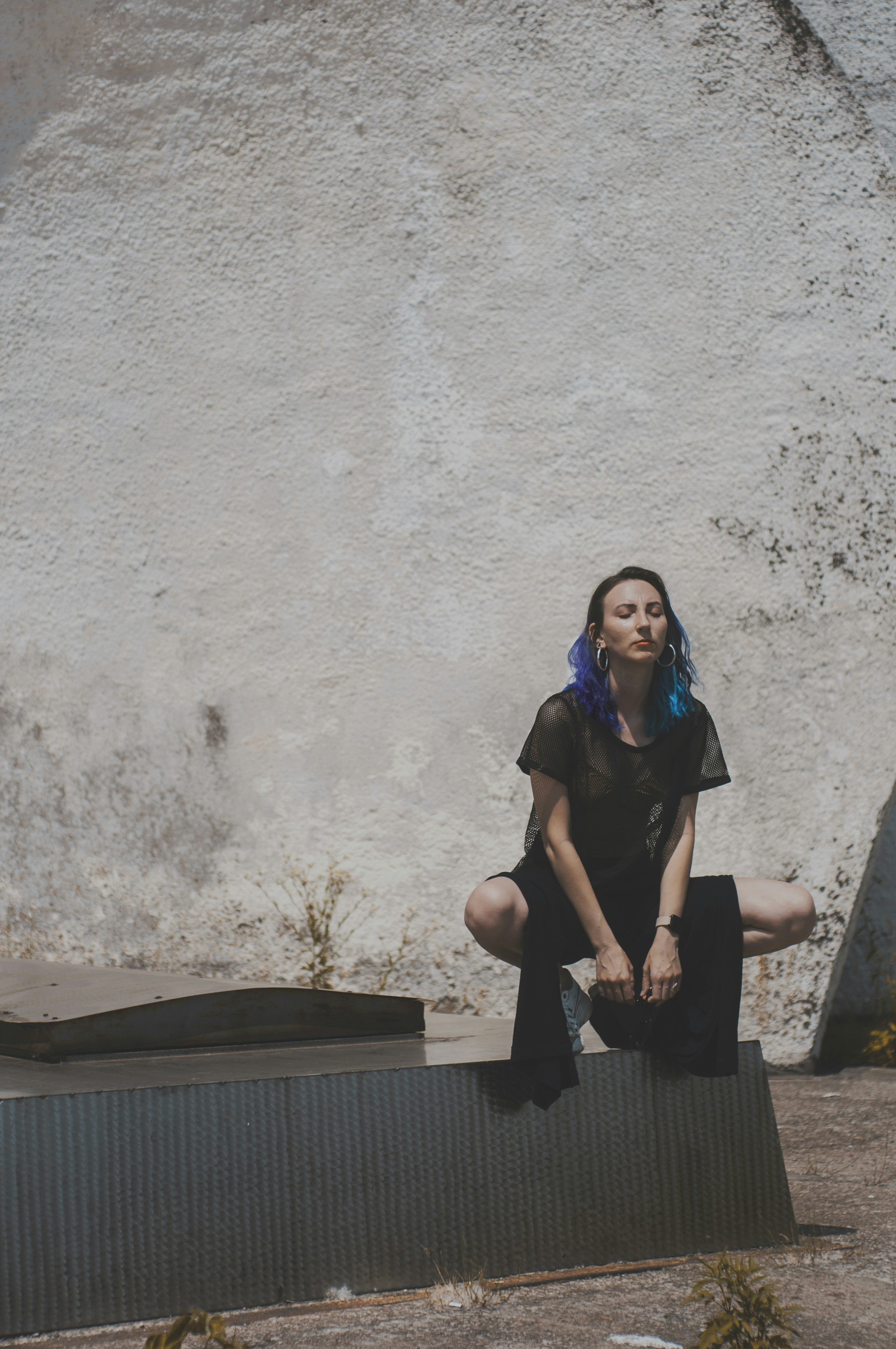 woman wearing black dress sitting on pavement