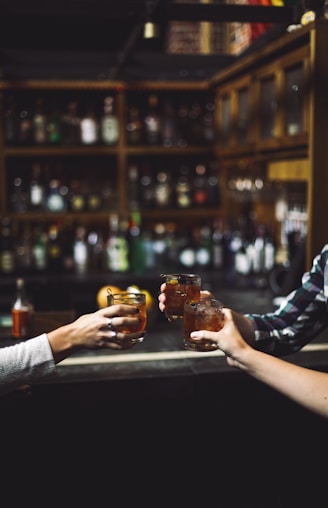 three person holding clear drinking glasses