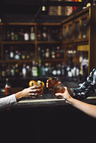 three person holding clear drinking glasses