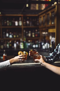 three person holding clear drinking glasses