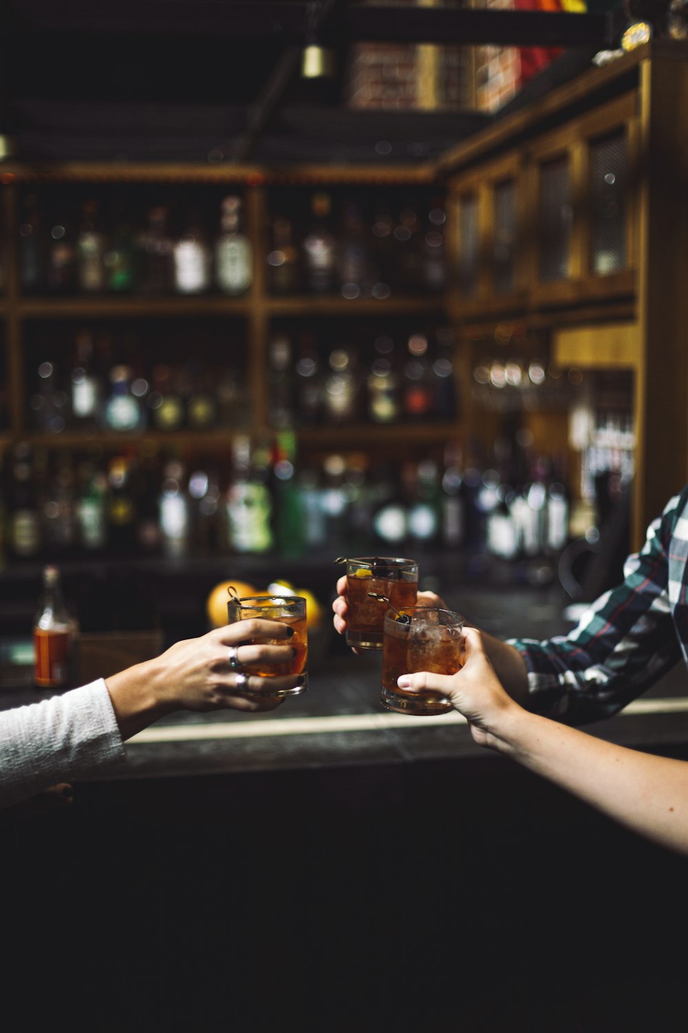 three person holding clear drinking glasses