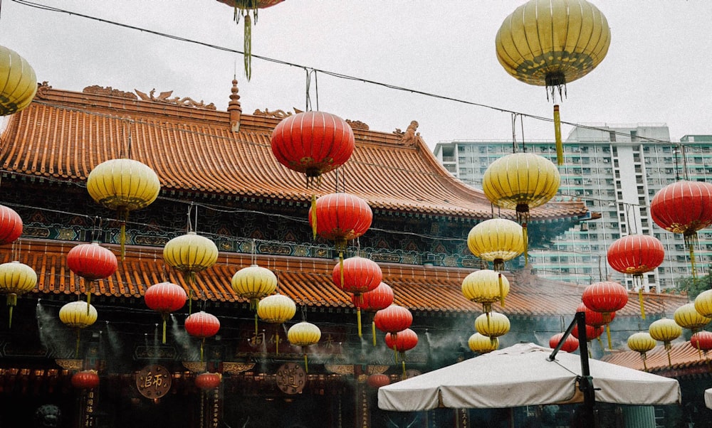 red and yellow paper lanterns hanging besides white canopy tent