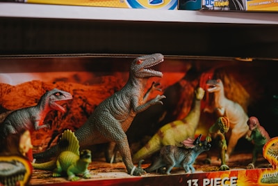 A vibrant collection of dinosaur-themed merchandise including shirts, posters, and shoes.