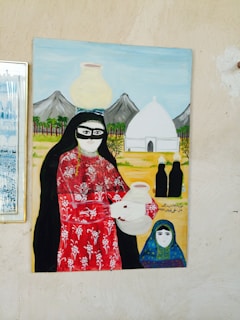 A painting depicts a woman in traditional attire carrying a large clay pot on her head and holding another in her hands, with a child standing beside her. Mountains and a white domed building are seen in the background, and there are palm trees and two figures dressed in black cloaks in the scene.