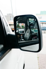 Interior view of a modern pink mirror branded car with a relaxed female passenger.