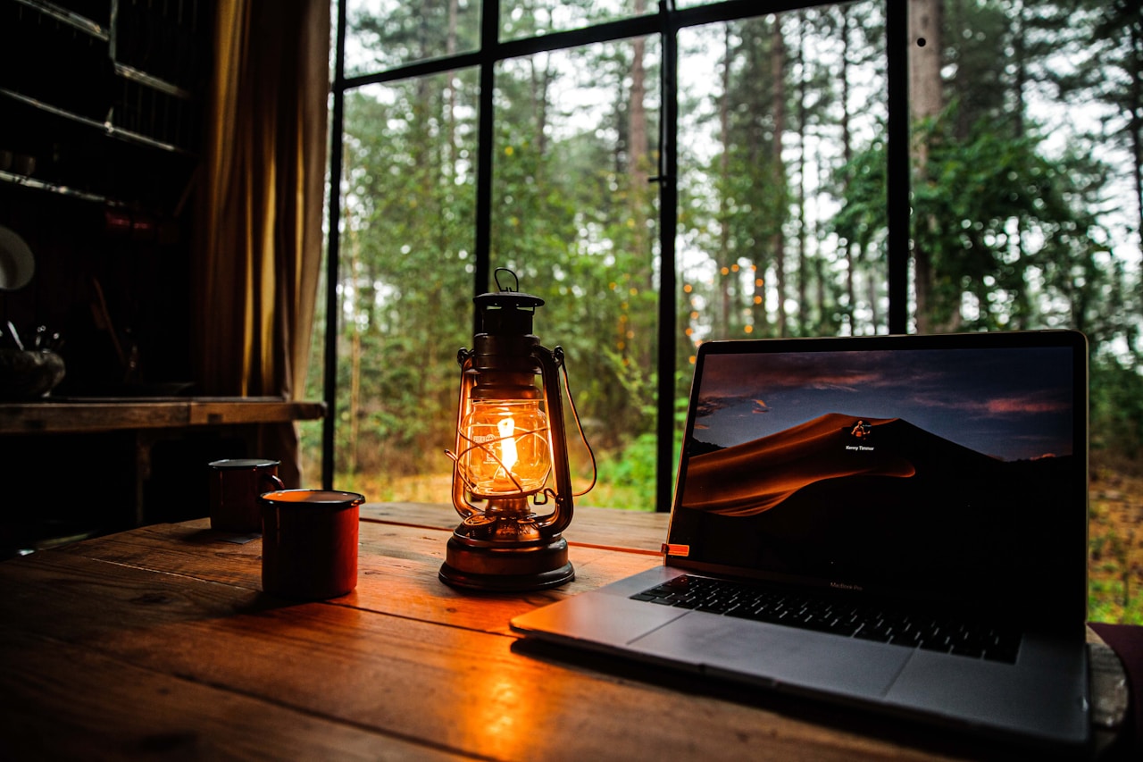 Laptop and smartphone on desk with notebooks